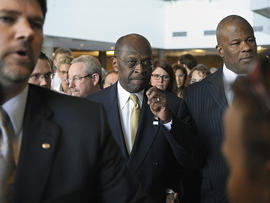Republican presidential candidate Herman Cain, center, is surrounded by security and staff as he walks through a hotel lobby in Alexandria, Va., Nov. 2, 2011, before speaking after meeting with doctors attending the Docs4PatientCare conference.