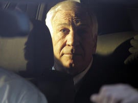 Former Penn State assistant football coach Jerry Sandusky sits in the back seat of his attorney's car as he leaves the Centre County Courthouse in Bellefonte, Pa., Dec. 13, 2011.