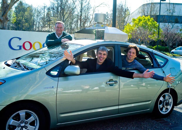 Google's top leaders pose in a Google self-driving car. From left to right are Executive Chairman Eric Schmidt, Chief Executive Larry Page, and co-founder Sergey Brin.