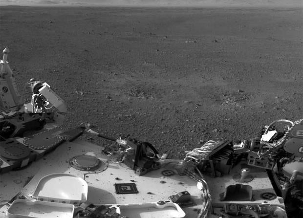 This mosaic image shows part of the left side of NASA's Curiosity rover and two blast marks from the descent stage's rocket engines. The images that were used to make the mosaic were obtained by the rover's Navigation cameras
