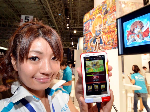A model displays a smartphone loading up a game at the booth of Japan's mobile social networking service company Gree at the annual Tokyo Game Show in Chiba, suburban Tokyo, on September 15, 2011. Some 200 companies from 16 countries exhibited their latest video game hardwares and softwares at a four-day vent. AFP PHOTO / Yoshikazu TSUNO (Photo credit should read YOSHIKAZU TSUNO/AFP/Getty Images)