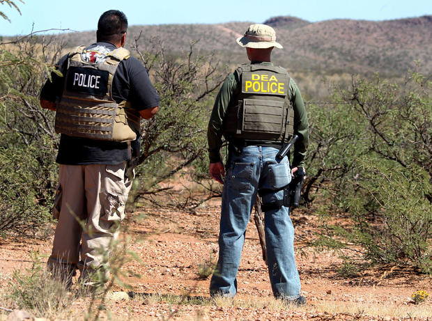 Det. Bill Silva, left, with the Bisbee Police Department, and an unnamed agent with the Drug Enforcement Administration patrol a fence line east of Naco, Ariz., after a Border Patrol agent was killed early Tuesday, Oct. 2, 2012.