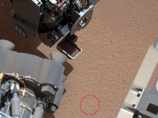 Mars rover Curiosity used the scoop at the end of its robotic arm for the first time, and discovered a small bright object (circled in red) on the surface.