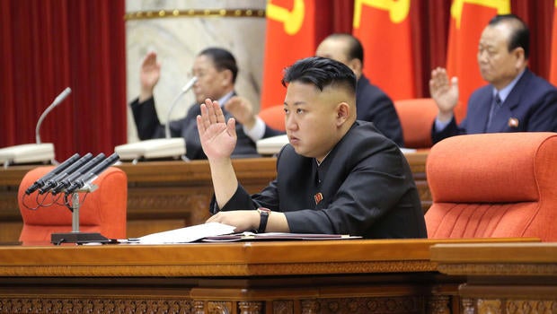 In this Sunday, March 31, 2013 photo released by the Korean Central News Agency (KCNA) and distributed in Tokyo Monday, April 1, 2013 by the Korea News Service, North Korean leader Kim Jong Un raises his hand with other officials to adopt a statement during a plenary meeting of the central committee of the ruling Workers' Party in Pyongyang, North Korea.