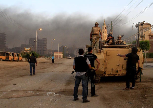 Egyptian security forces take cover during clashes with suspected militants, not pictured, in the town of Kerdasa