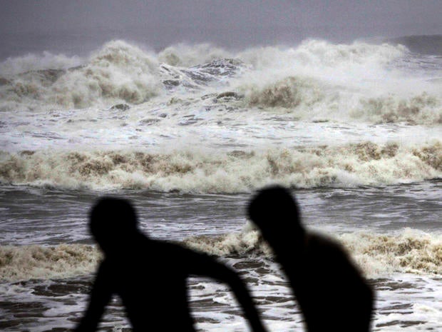 Indian people run for shelter following a cyclone warning at the Bay of Bengal coast in Gopalpur beach in Ganjam district, India, Oct. 12, 2013.