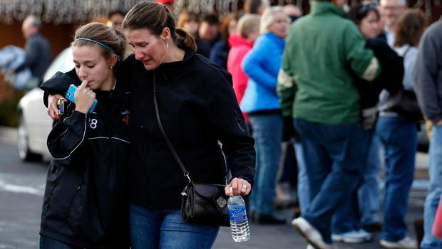 A parent picks up her daughter at a church where students from nearby Arapahoe High School were evacuated after a shooting on the Centennial, Colo., campus Dec. 13, 2013.