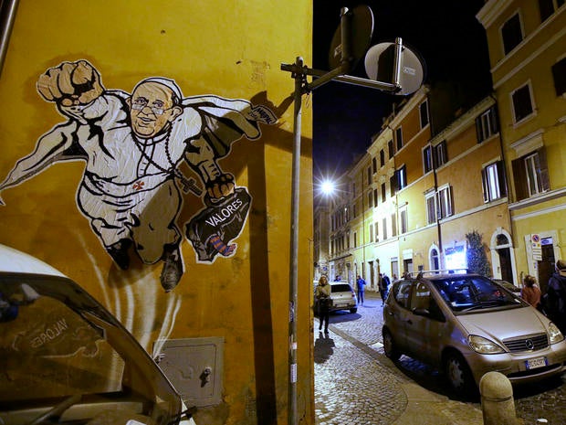 Graffiti depicting Pope Francis as a Superman-like hero, clutching a bag with the Spanish word for "Values," is seen on a wall of the Borgo Pio district near St. Peter's Square