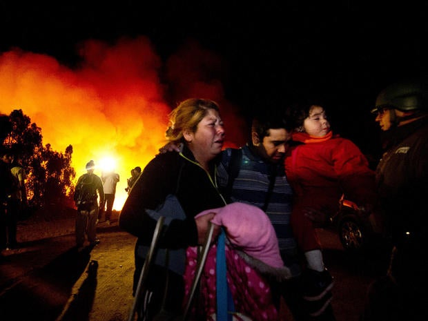 People flee to safety after a wildfire reactivated in Valparaiso