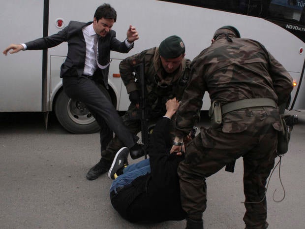 A protester is kicked by Yusuf Yerkel (L), advisor to Turkey's Prime Minister Tayyip Erdogan, as Special Forces police officers detain him during a protest against Erdogan's visit to Soma, a district in Turkey's western province of Manisa