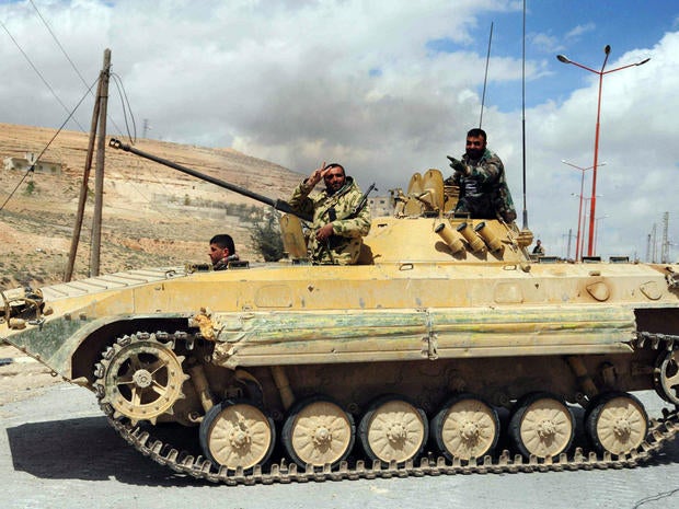 Syrian soldiers flash the sign for victory as they drive a tank in al-Sarkha village in the Qalamun mountains, northeast of Damascus, after taking control of the village from rebel fighters April 14, 2014.