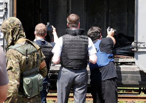 Monitors from the OSCE inspect a refrigerator wagon holding bodies of passengers from Malaysia Airlines flight 17