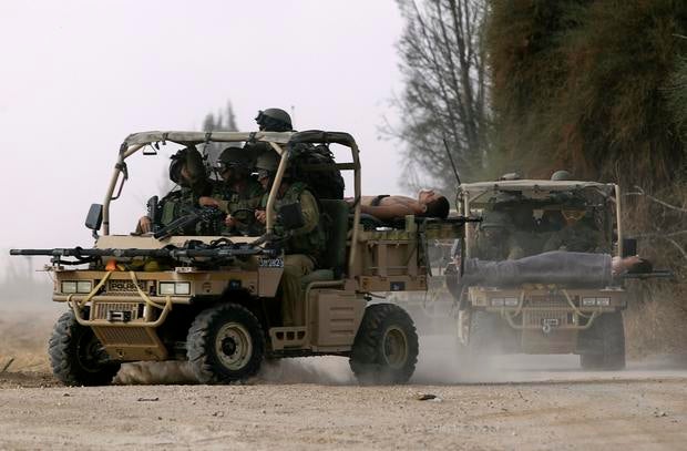 Israeli soldiers, wounded during an offensive in Gaza, are evacuated near the border with the central Gaza Strip