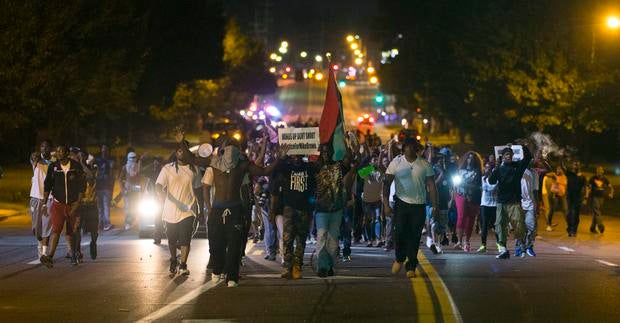 Demonstrators march in street while protesting the shooting death of Michael Brown in Ferguson, Missouri on August 12, 2014