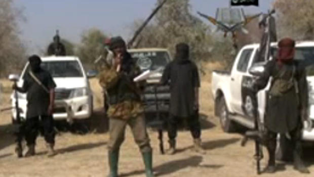 Boko Haram militants, and at center, the man claiming to be the group's leader, Abubakar Shekau, appear in a propaganda video