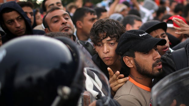 Migrants are held back by Slovenian riot police at the border in the small Croatian village of Harmica Sept. 19, 2015, in Harmica, Croatia.