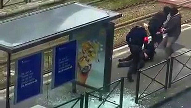 Belgian police drag a suspect along a tramway platform after the suspect was shot in this still image taken from amateur video in the Brussels borough of Schaerbeek March 25, 2016, three days after the bombings in Brussels, Belgium.