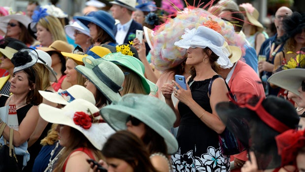 Fans in derby hats take photos as celebrities arrive on the red carpet before the 142nd running of the Kentucky Derby at Churchill Downs.