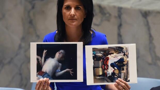 U.S. Ambassador to the U.N. Nikki Haley holds photos of victims as she speaks as the U.N. Security Council meets in an emergency session at the U.N. on April 5, 2017.