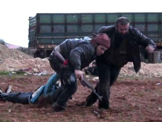 Syrian rebels drag away a wounded fighter after a battle with President Assad's military forces