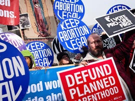 An anti-abortion-rights activist stands in front of pro-abortion-rights activists with the National Organization for Women at a vigil outside the U.S. Supreme Court Jan. 23, 2012, in Washington.