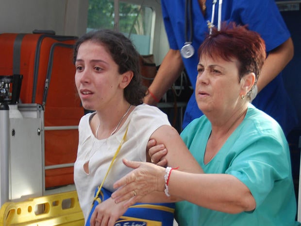 Unidentified Israeli tourist is helped as she arrives to Bourgas hospital after a bus carrying Israeli tourists in the Bulgarian resort city of Bourgas exploded Wednesday.