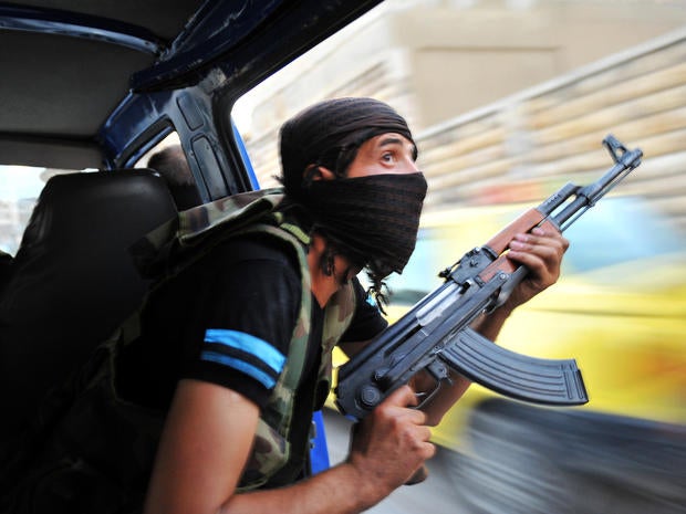 Syrian rebels hunt for snipers after attacking the municipality building in the city center of Selehattin, Syria, July 23, 2012, during fights between rebels and Syrian troops.
