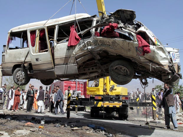 A damaged bus that was hit by a remote-controlled bomb is lifted by a crane on the outskirts of Kabul, Afghanistan, Aug. 7, 2012.