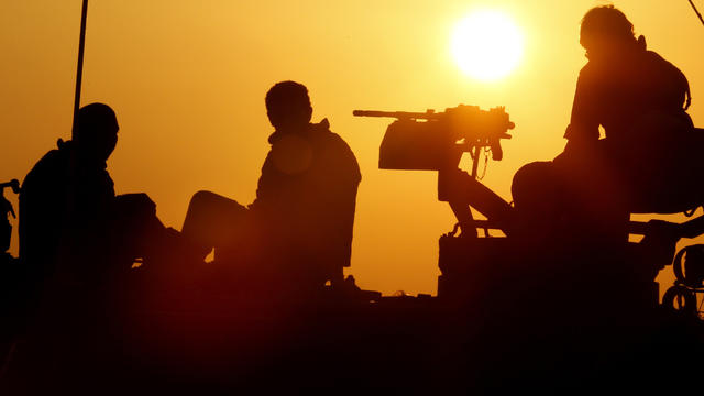 Israeli soldiers sit on top of a mobile artillery cannon unit at an Israeli army deployment area near the Israel-Gaza Strip border Nov. 20, 2012. 