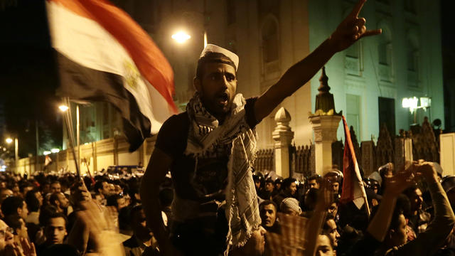 Egyptian protesters chant slogans against the Muslim Brotherhood and Egyptian President Mohammed Morsi outside the presidential palace after they broke a barbed wire barricade in Cairo Dec. 7, 2012. 