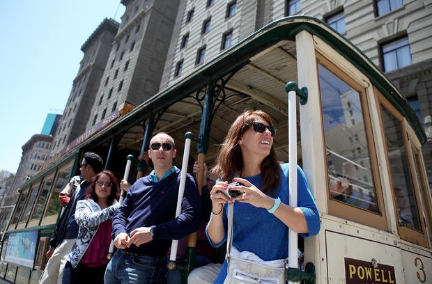 Passengers ride a cable car as it travels along Powell Street on June 9, 2011 in San Francisco, California.