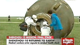 Crew attends to the recently landed Shenzhou 10 spacecraft, carrying three astronauts, as seen on Chinese television on June 25, 2013.