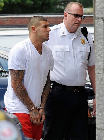 New England Patriots tight end Aaron Hernandez, left, is led into Attleboro District Court for court June 26, 2013, in Attleboro, Mass. 