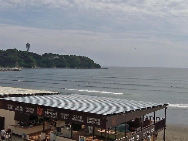 Windsurfers enjoy the early summer waves in the Japanese beach resort of Enoshima