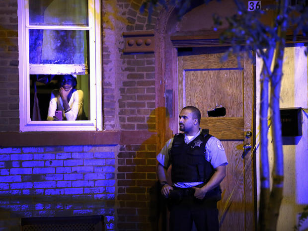 A police officer stands guard outside a home in Chicago where a man was shot in the chest in the Humboldt Park neighborhood on the city's West Side Sept. 20, 2013. 