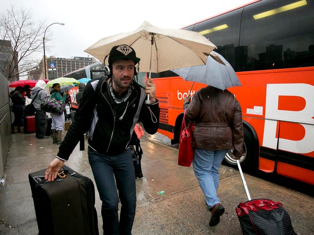 Passengers board a BoltBus during a light rain Nov. 27, 2013, in New York.