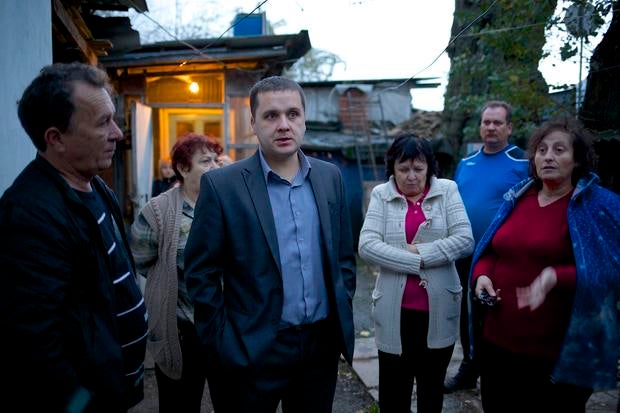 Igor Zarytovsky, center, and his father Vladimir, left, gather with their neighbors in the yard of the railroad house in the village of Vesyoloye outside Sochi, Russia.