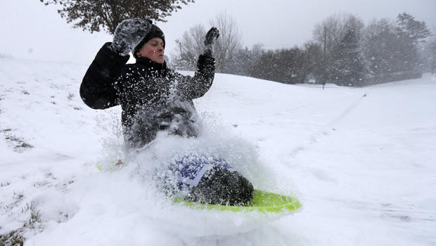 Stephen Clark, 12, hits a ramp made of snow as he sleds near his home in Charlotte, N.C., Feb. 12, 2014, as a winter storm moves into the area. 