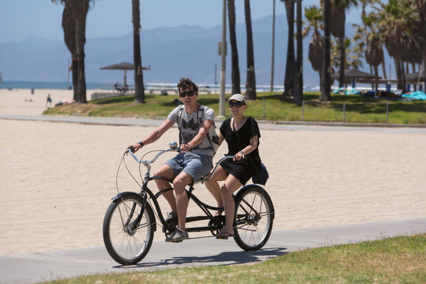 Bicycle riders riding a a tandem bicycle on the beachfront bike path at Venice 