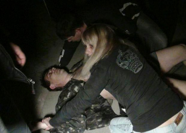 People surround a man who was injured during pro-Russian protests near a Ukrainian military base in Mariupol