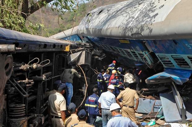 Rescuers search for survivors from the debris of a passenger train after it derailed near Nidi village, south of Mumbai, in the western Indian state of Maharashtra