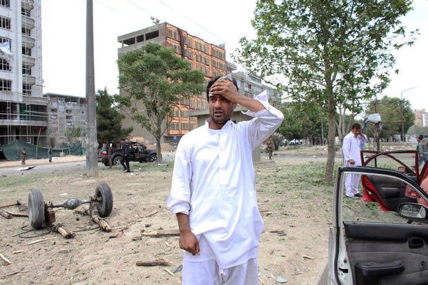 man reacts at the site of a suicide attack that struck the convoy of presidential candidate Abdullah Abdullah