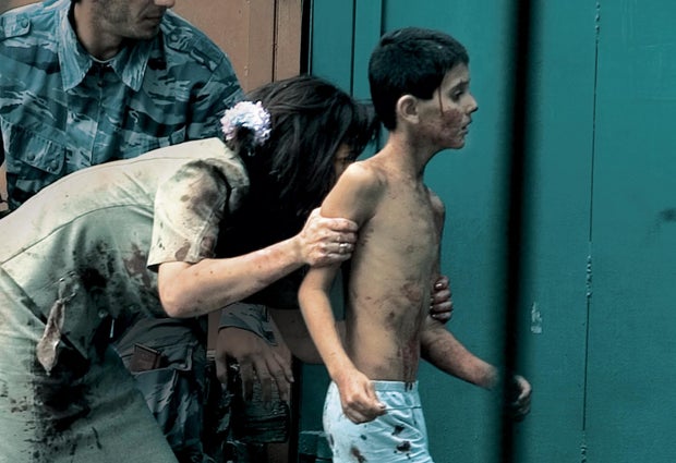 Teacher Elena Kosumova runs to safety with her son, Timor. 