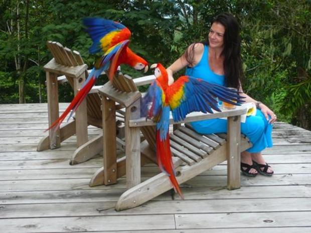 Ann Bender with colorful macaws at Boracayan 