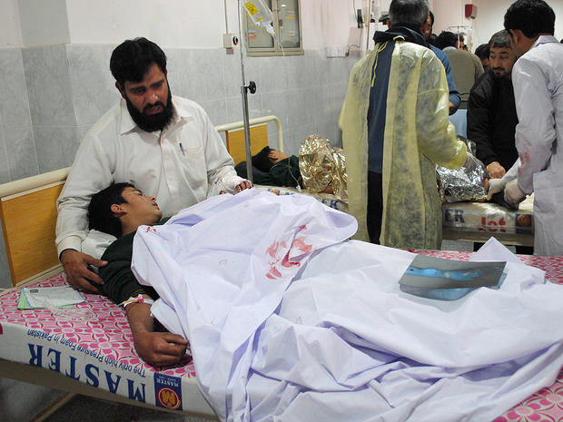 A man comforts his son, who was injured during an attack by Taliban gunmen on the Army Public School, at Lady Reading Hospital in Peshawar 