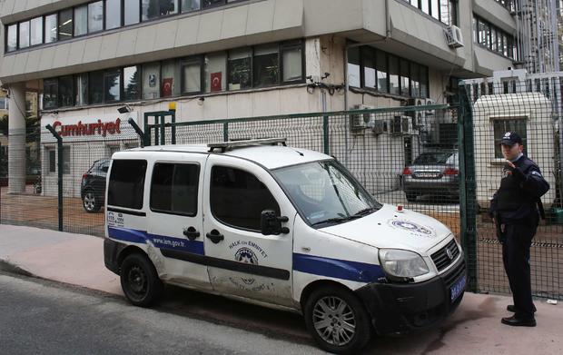 A police officer stands guard at the entrance of the offices of daily newspaper Cumhuriyet in Istanbul 