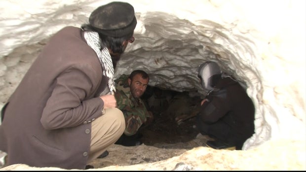 Residents tunnel into a snow drift to try and find survivors after an avalanche slammed into Ghasha village, in Afghanistan's Panjshir province 