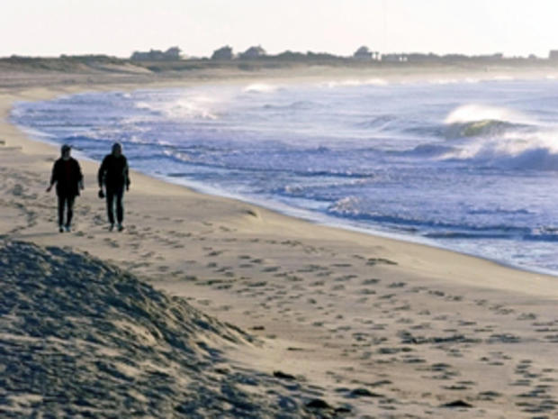 Two women walk along Surfside beach 01 November 19 