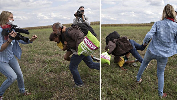 A migrant falls over a child as he tries to run away from the police on a field near a collection point in the village of Roszke