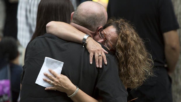 People embrace during a ceremony marking the 14th anniversary of the 9/11 attacks at the National September 11 Memorial and Museum in Lower Manhattan in New York Sept. 11, 2015.